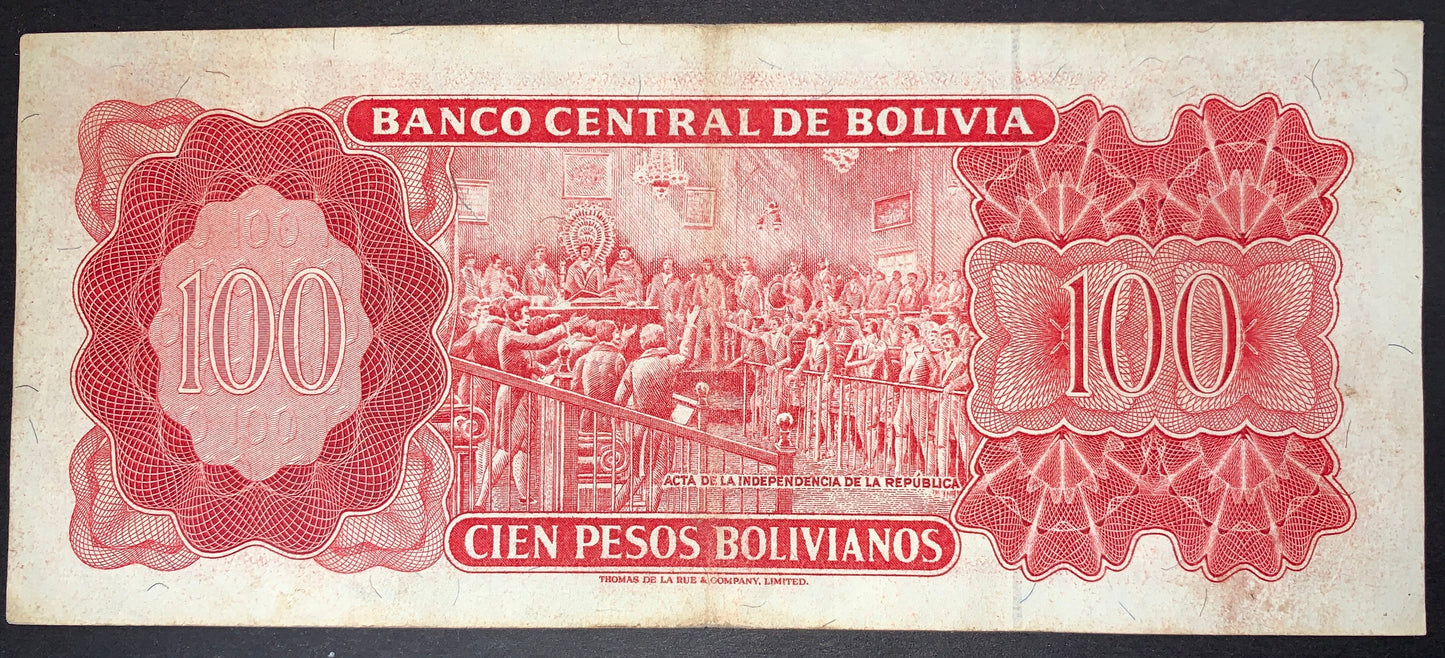Reverse of an authentic Bolivia 100 Pesos Bolivianos banknote, 1962 issue, Pick P-164b. Depicts the signing of the Bolivian Declaration of Independence, surrounded by intricate red guilloche designs and large 100 denomination panels.