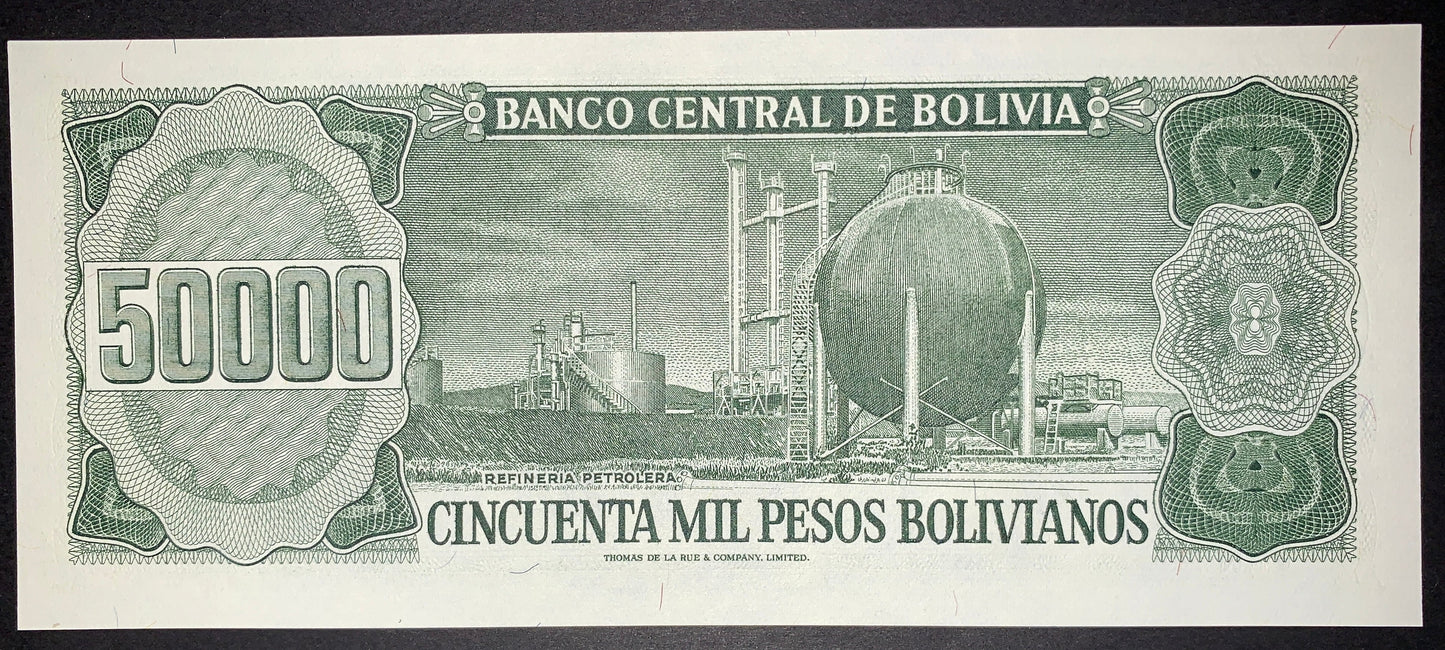 Reverse of an authentic Bolivia 50,000 Pesos Bolivianos banknote, 1984 issue, Pick P-170. Features an industrial petroleum refinery with detailed engraved linework, ornate guilloche patterns, and the large 50,000 denomination.