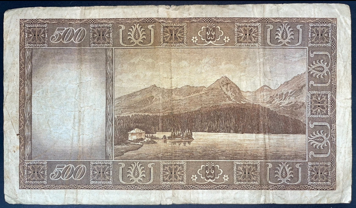 Reverse of a Czechoslovakia 500 Korun 1946 banknote, depicting a scenic mountain landscape with a lake, forest, and lakeside building, surrounded by an ornate decorative border.