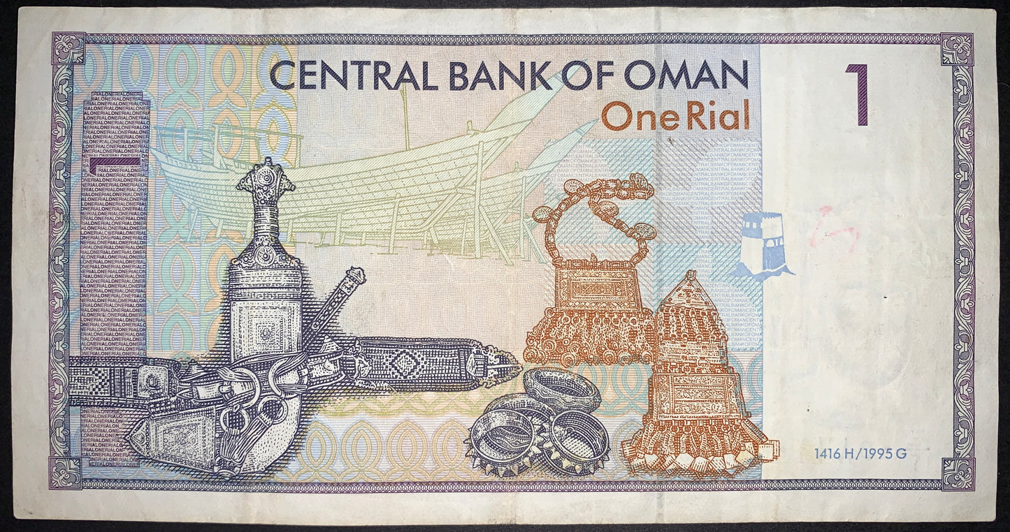 back of Oman 1 Rial 1995 P-21 F vintage collectible banknote with building, jewelry, and weapons