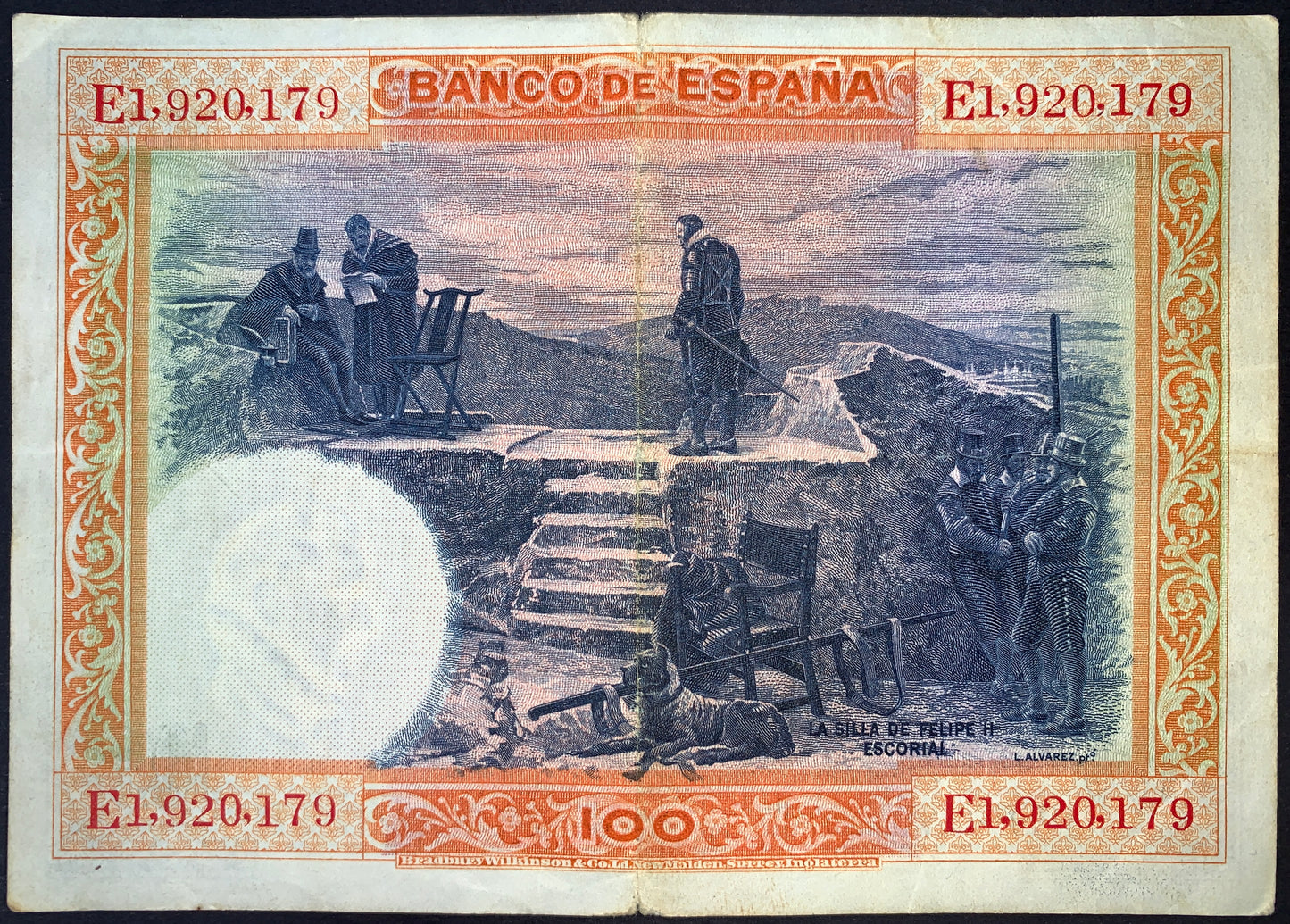 Reverse of Spain 100 Pesetas 1925 banknote (P-69c) depicting “La Silla de Felipe II” near El Escorial, with figures in period clothing gathered in a historic landscape. Intricately engraved multicolor design framed by ornate orange borders.