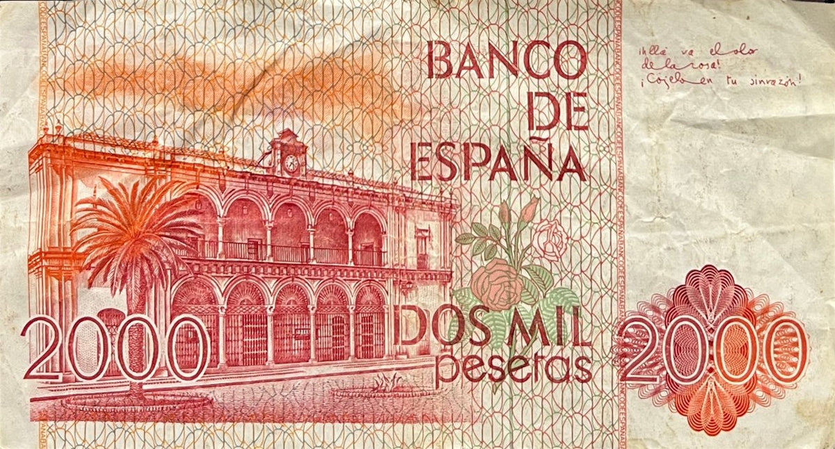 Back view of a 1980 Spain 2000 Pesetas banknote showing the town hall of Moguer with a palm tree, roses and handwritten verse.