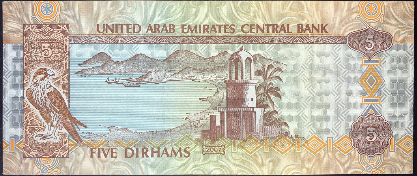 Reverse of UAE 5 Dirhams 2007 P-19d banknote featuring a falcon, coastal bay landscape, traditional watchtower, and Five Dirhams denomination
