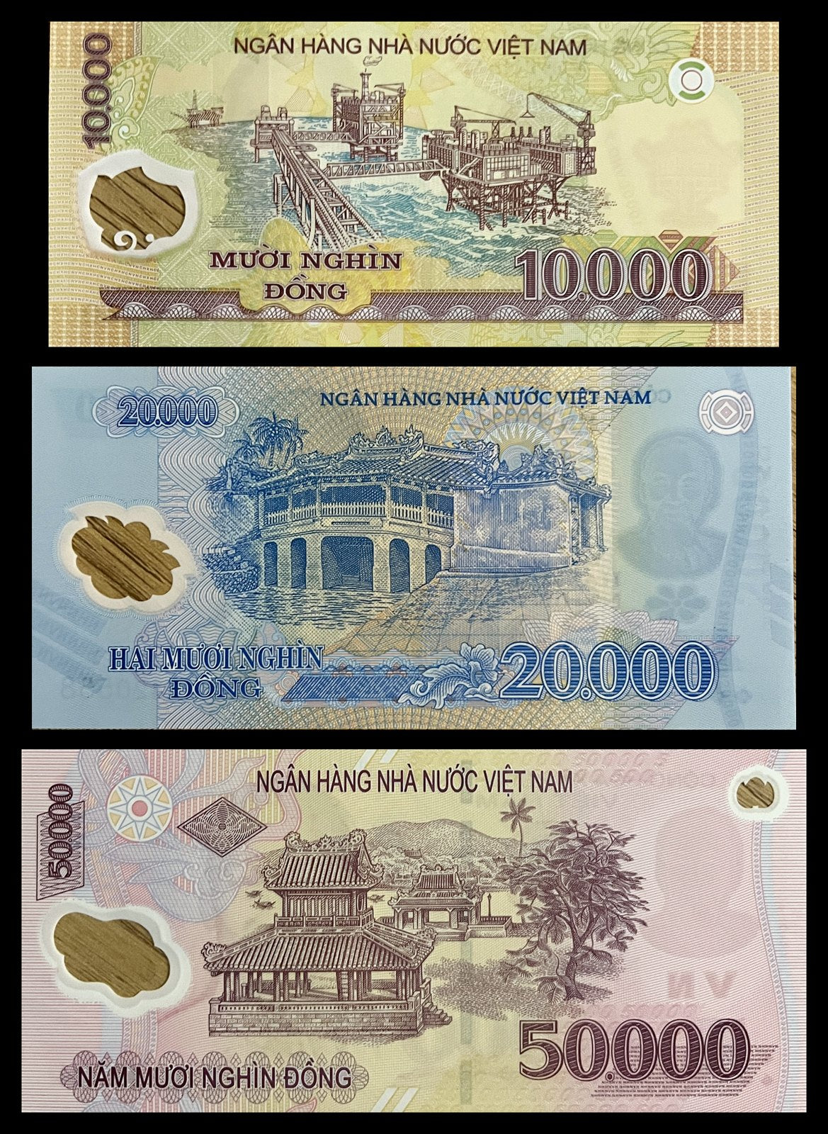 Back view of a Vietnam 10,000, 20,000 and 50,000 Dong polymer set showing the Bạch Hổ offshore oil rig, the Japanese Covered Bridge of Hội An and the Phu Văn Lâu pavilion in Huế.