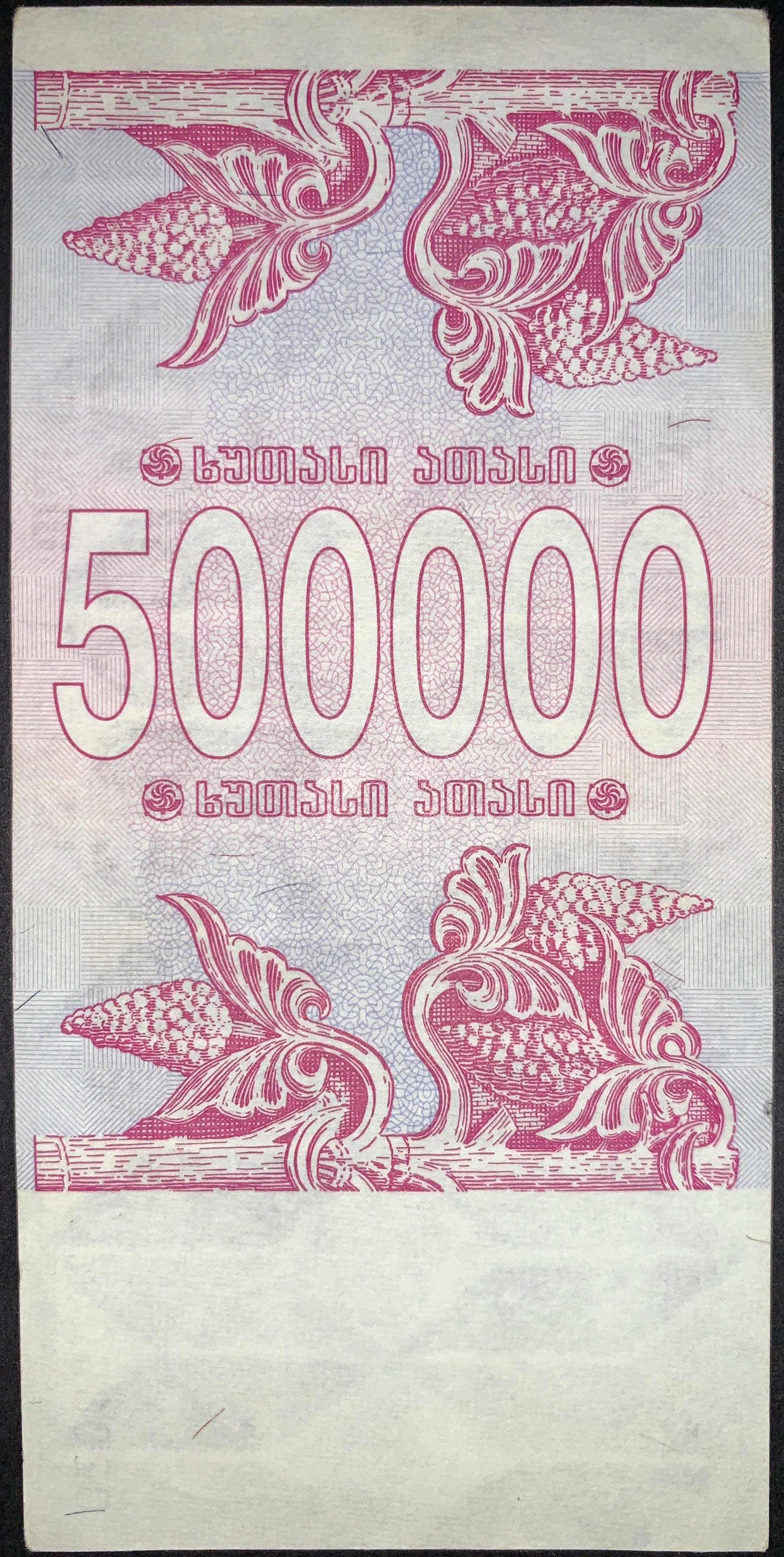 Reverse of the 500,000 Kuponi note with ornate floral decorations, detailed security patterns, and oversized denomination numerals. Printed in pink and lavender tones with traditional ornamental styling.