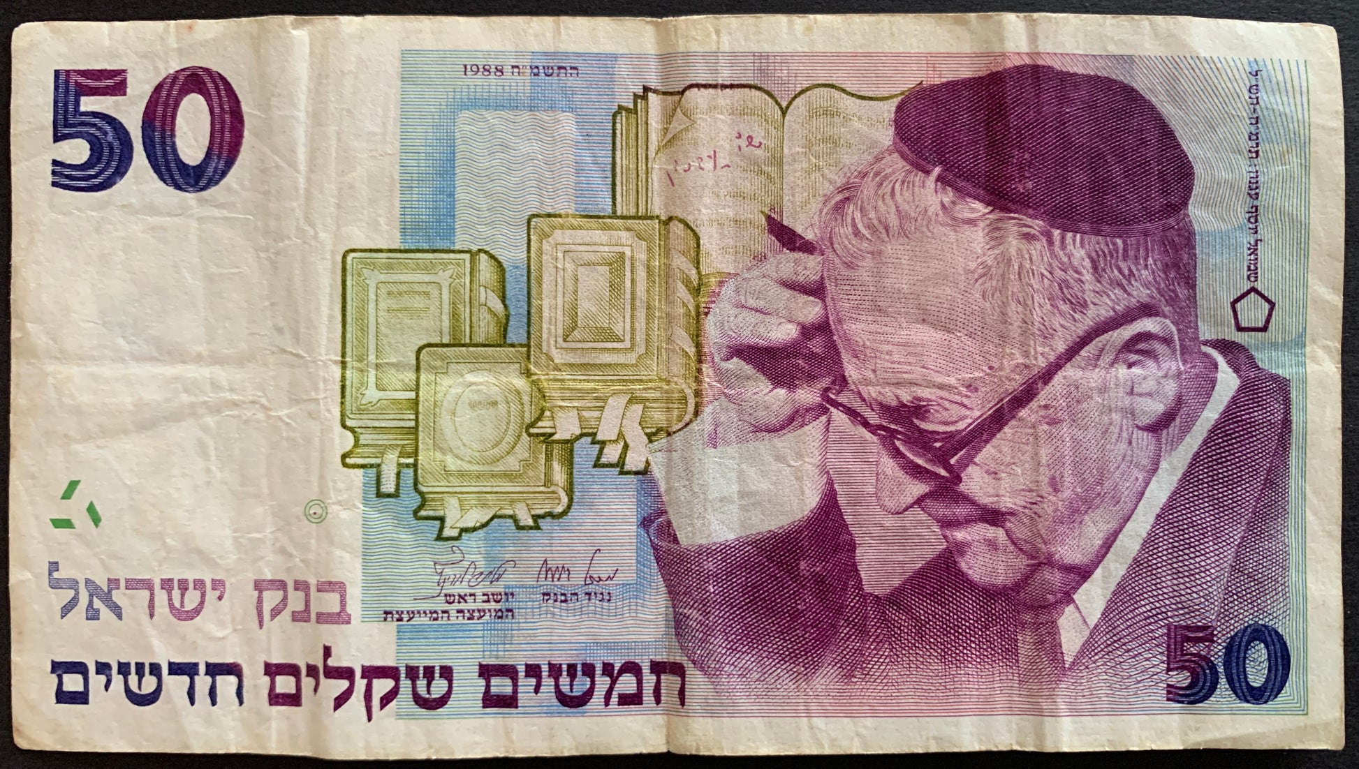 Israeli 50 shekels banknote featuring a person with glasses and books.