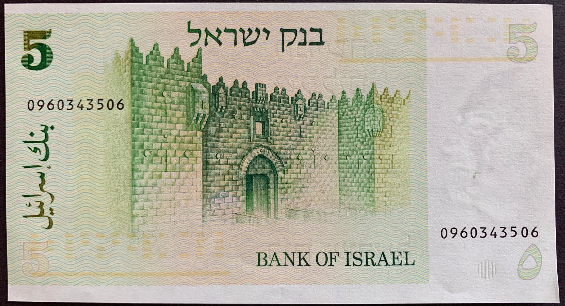 Banknote with a castle design and text indicating 'Bank of Israel' on a light green background.