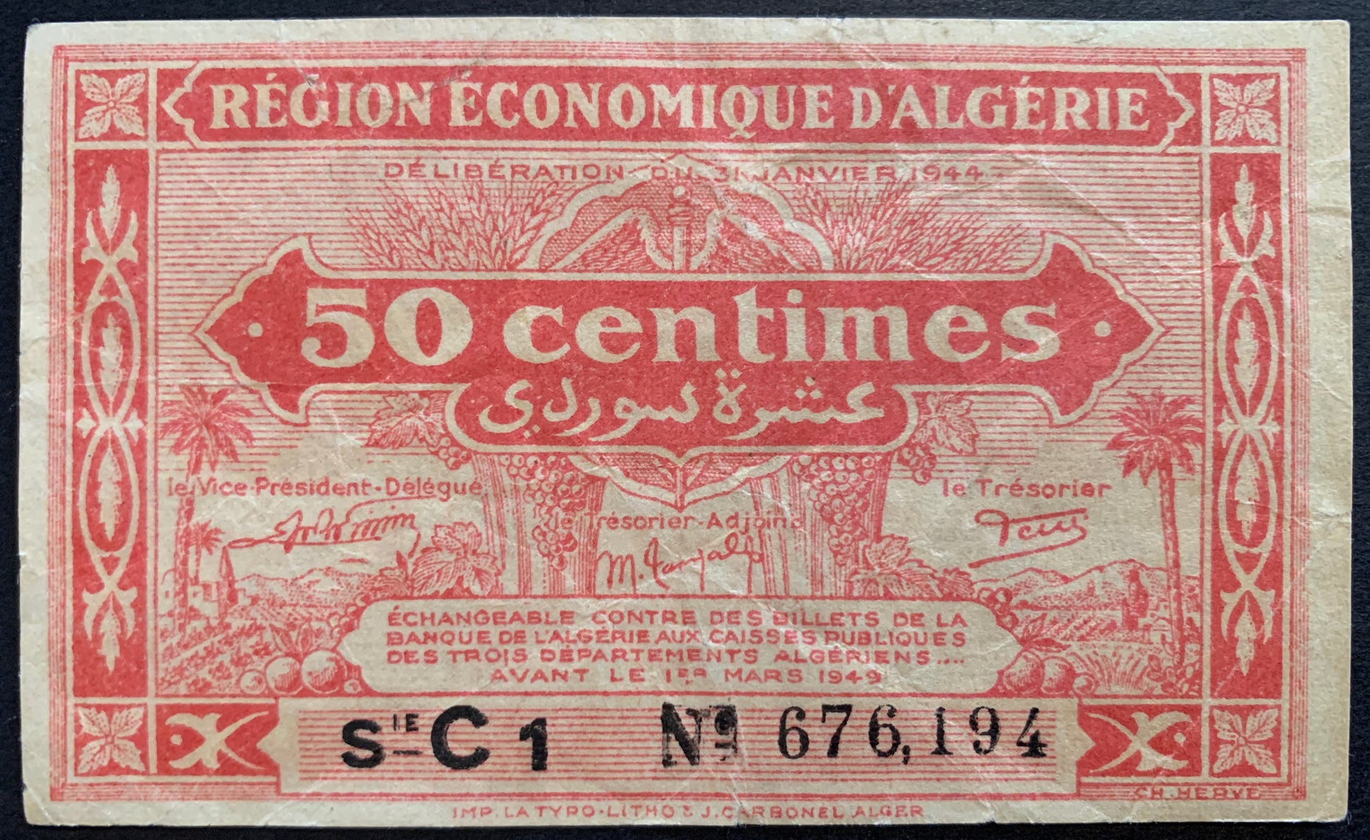front of Algeria 50 Centimes 1944 P-97a collectible vintage banknote with floral frame; country scene represented by palm trees, fruits, a sheaf of wheat, an agricultural field and a village in the distance
