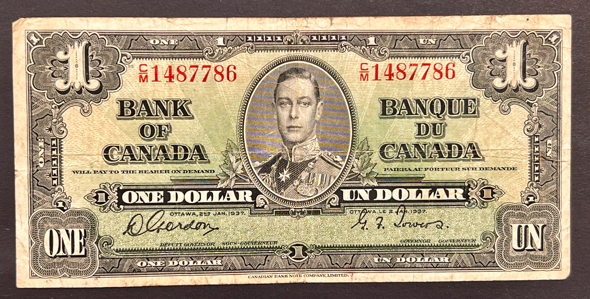 A vintage Canadian one dollar banknote from 1937, featuring a portrait of King George V in the center, with 'BANK OF CANADA' and 'BANQUE DU CANADA' printed on both sides, shown against a dark background.