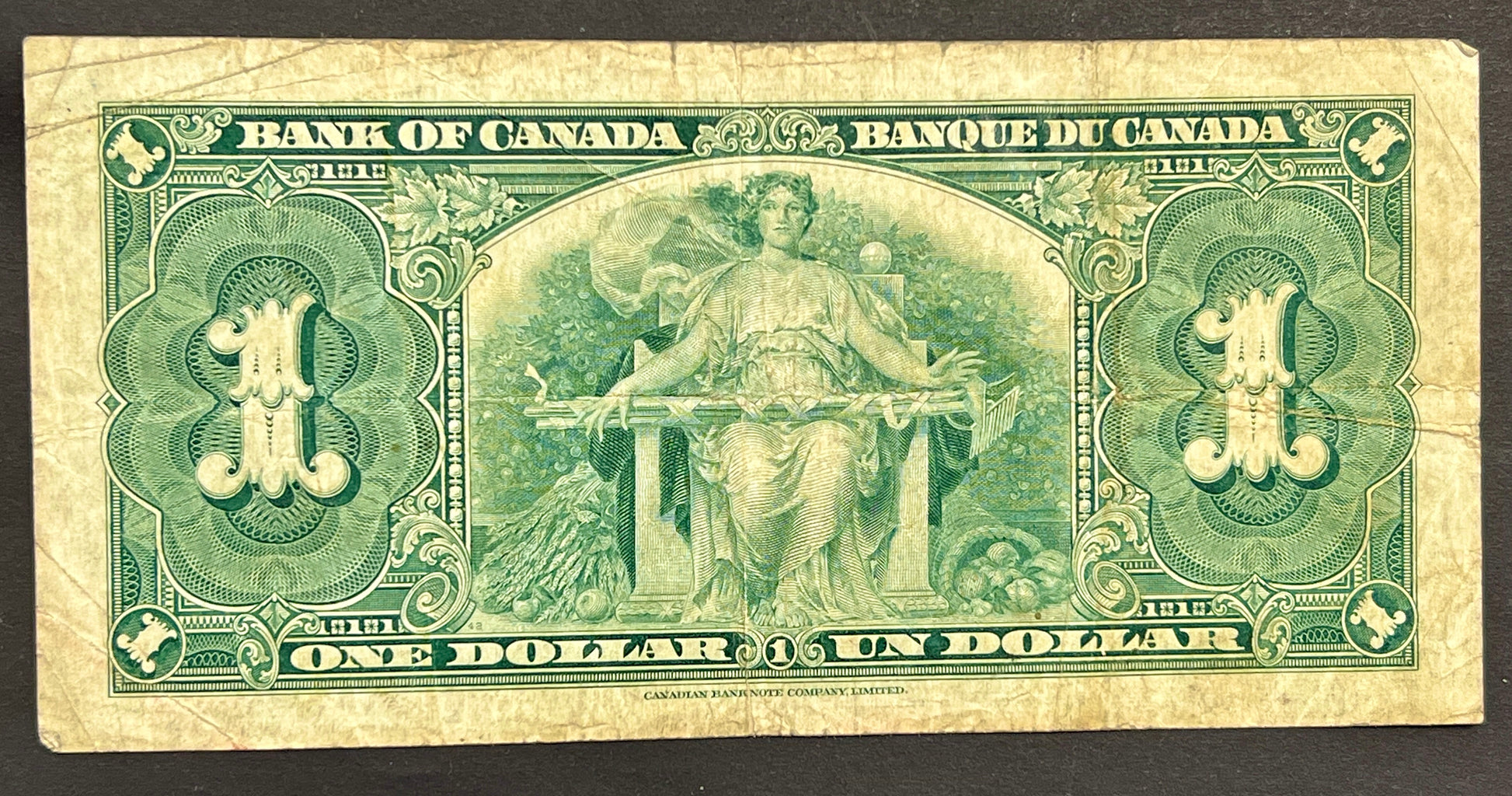 A vintage Canadian one dollar banknote from 1935, featuring green printed details and an illustration of a seated female figure, shown against a dark background.
