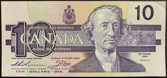 Front of the 1989 Canada 10 Dollar banknote (P-96a) featuring the portrait of Sir John A. Macdonald, with a detailed Parliament vignette and multicolored intaglio security patterns