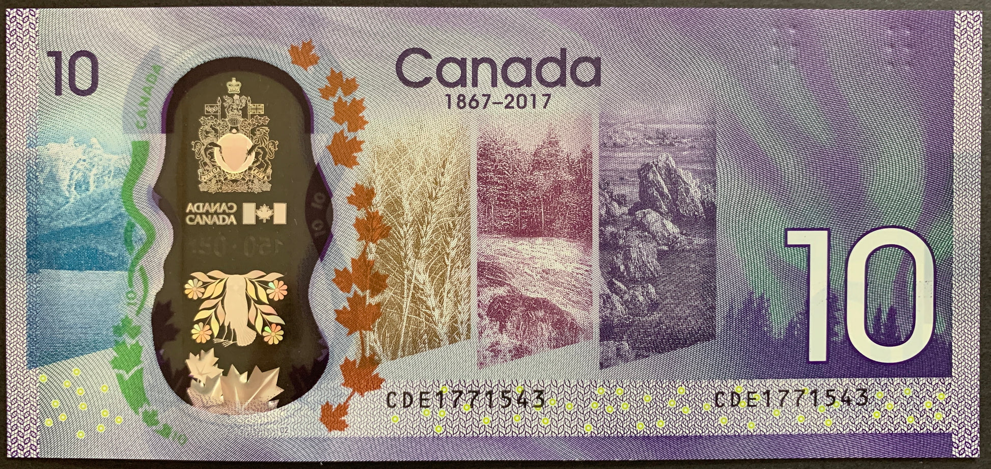 Back of the 2017 Canada 10 Dollar Canada 150 polymer banknote (P-112) displaying the multiscape design of Canadian landscapes including mountains, prairies, forests, and coastal regions, shown in UNC condition.