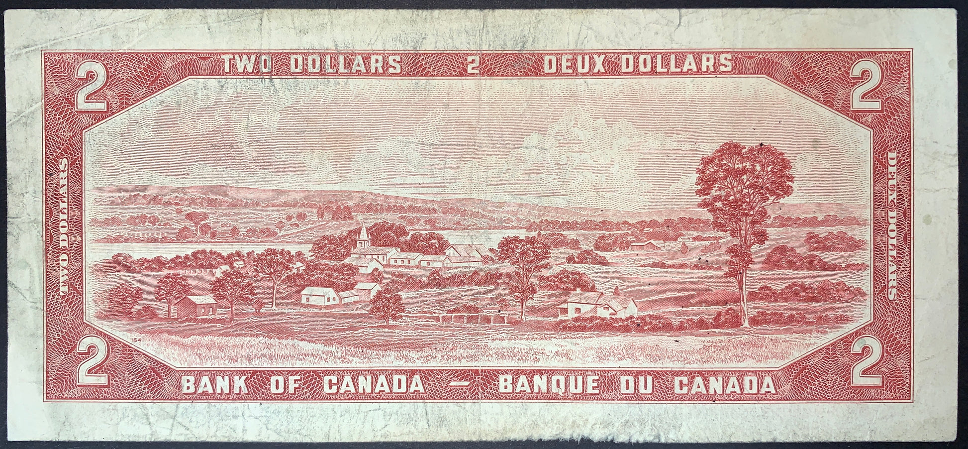 front of Canada 2 Dollars 1954 P-76c collectible vintage banknote with  rural scene from the Richmond region near Quebec City, with the rolling hills of Les Montérégiennes and the Saint-François River