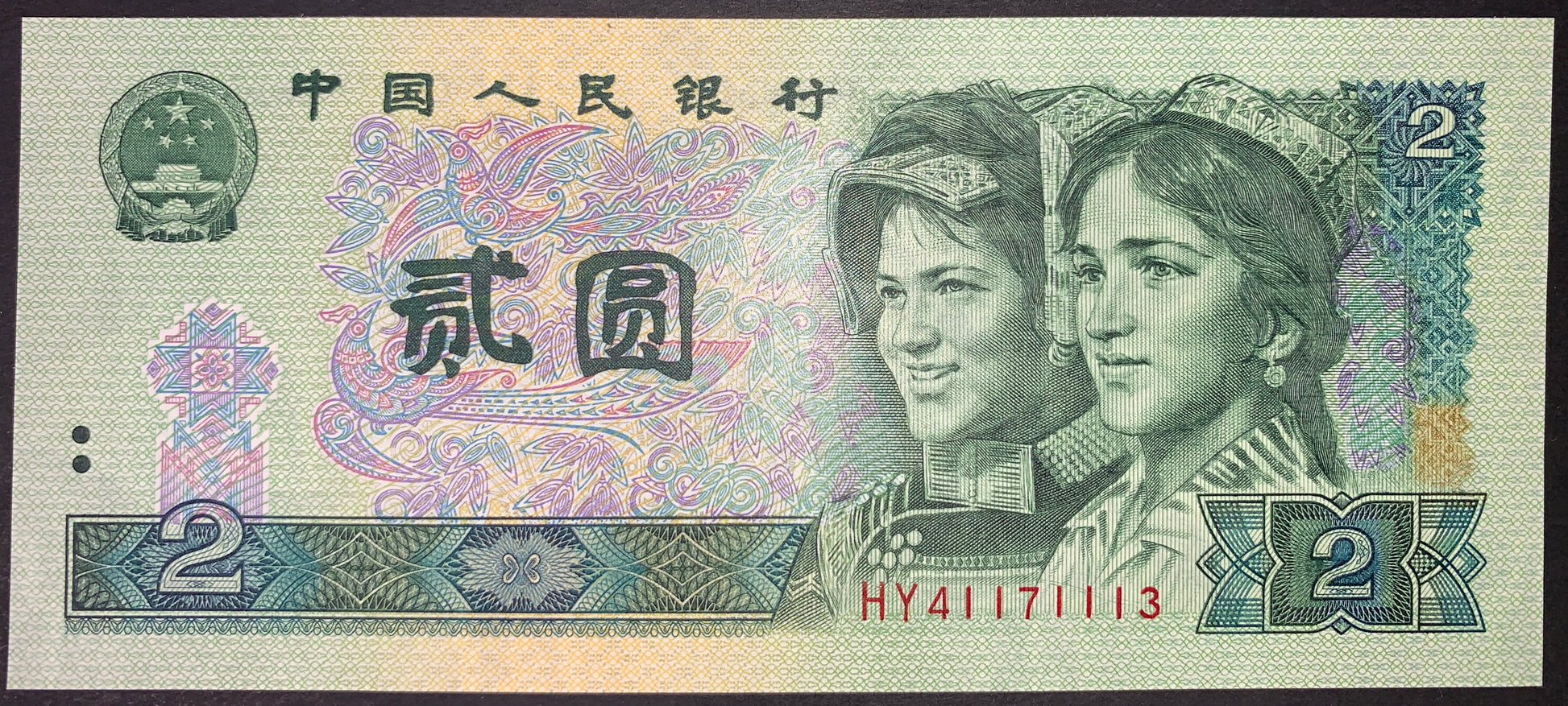 front of China 2 Yuan 1990 P-885 UNC collectible vintage banknote with portraits of Uygur and Yi youths and stylized birds
