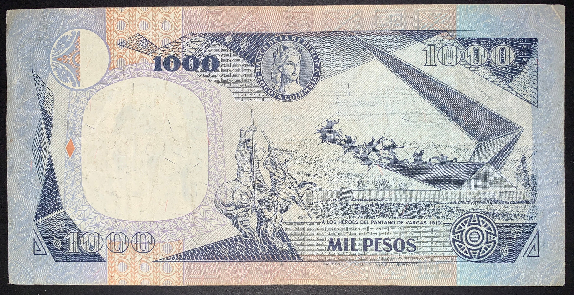 Reverse of an authentic Colombia 1,000 Pesos banknote, 1995 issue, Pick P-438. Depicts the Monument to the Heroes of Pantano de Vargas commemorating the 1819 battle, surrounded by intricate geometric designs and colorful security features.