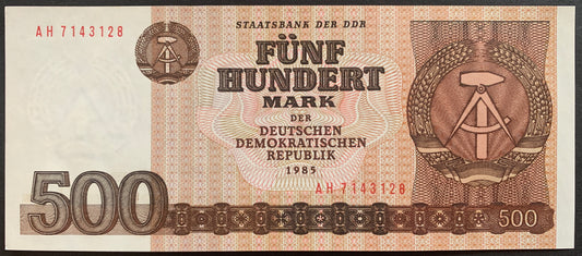 Front view of a crisp, uncirculated 1985 East Germany 500 Mark banknote featuring the DDR national emblem of a hammer and compass surrounded by rye.