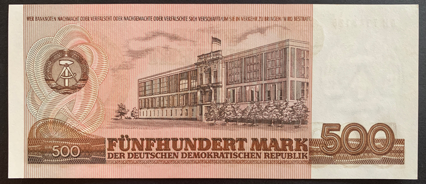 Back view of an unissued 1985 East Germany 500 Mark banknote showcasing a detailed engraving of the Staatsrat (State Council) building in East Berlin.
