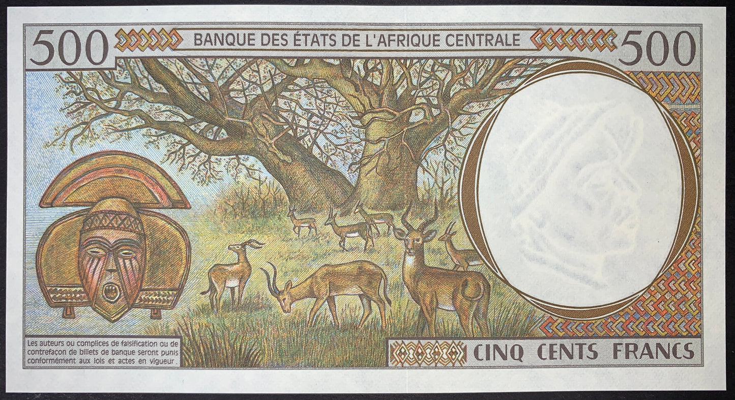 Reverse of the Gabon 500 Francs 1994 P-401Lb UNC banknote depicting a towering African baobab tree, graceful antelopes crossing the savannah, a traditional carved Kota tribal mask, and an antelope-head watermark. Authentic collectible banknote.