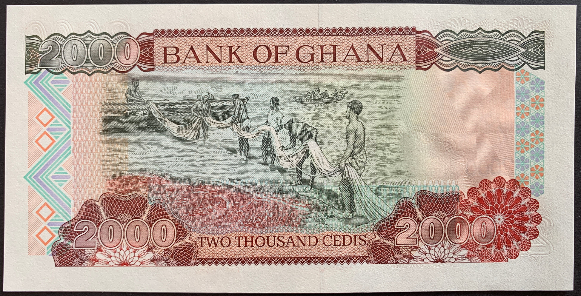 back of Ghana 2000 Cedis 2002 P-33g collectible banknote featuring fishermen with boat and fishing net