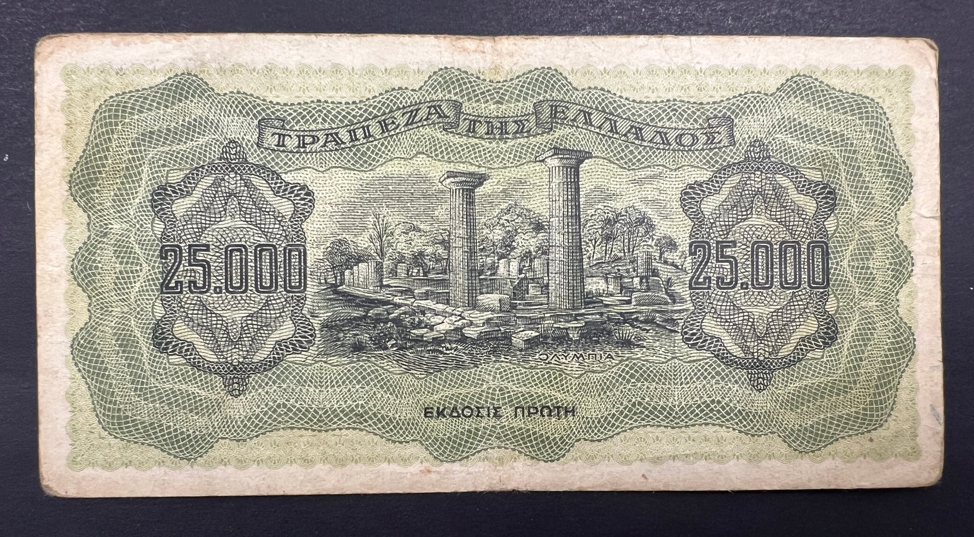 Back view of a vintage 1943 Greece 25000 Drachmai banknote showcasing an engraving of the ancient ruins of the Temple of Hera at Olympia.
