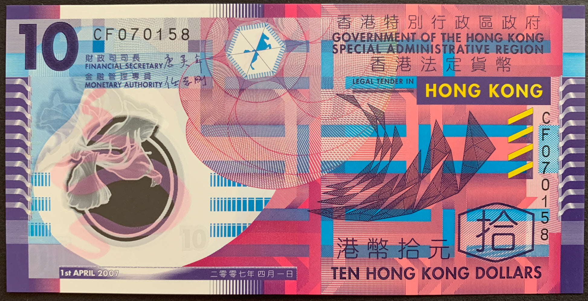 Front view of an uncirculated 2007 Hong Kong 10 Dollars polymer banknote featuring vibrant abstract geometric patterns and a transparent Bauhinia flower window.
