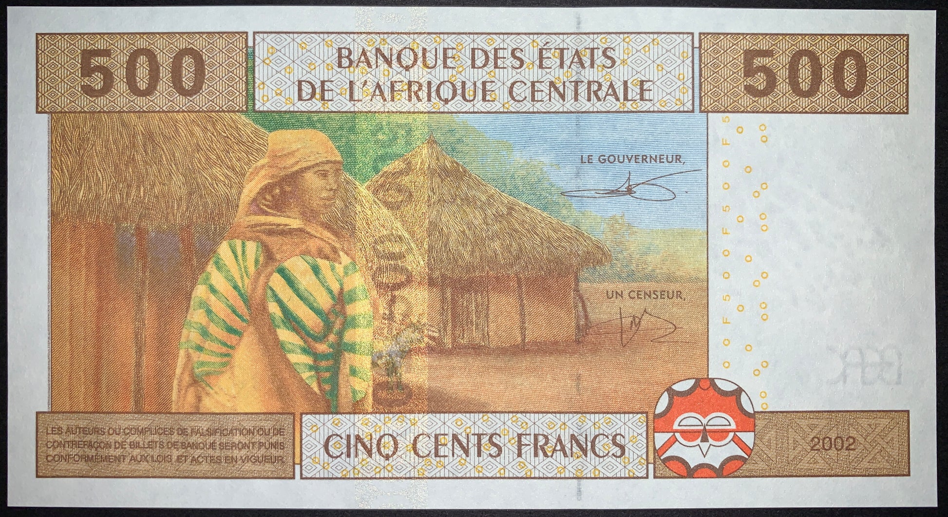 Reverse of the Central African States 500 Francs 2002 banknote (P-606Ca), depicting a traditionally dressed woman carrying a clay water vessel beside thatched village huts.