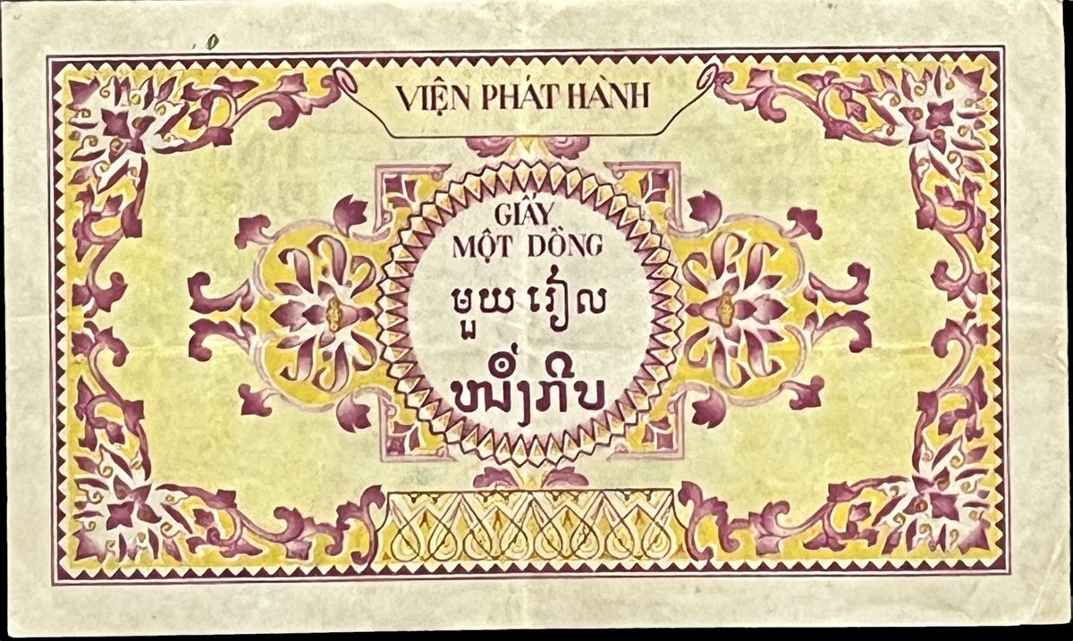 Back view of a 1953 French Indochina 1 Piastre banknote with a pink and yellow floral frame and the value written in Vietnamese, Khmer and Lao scripts.