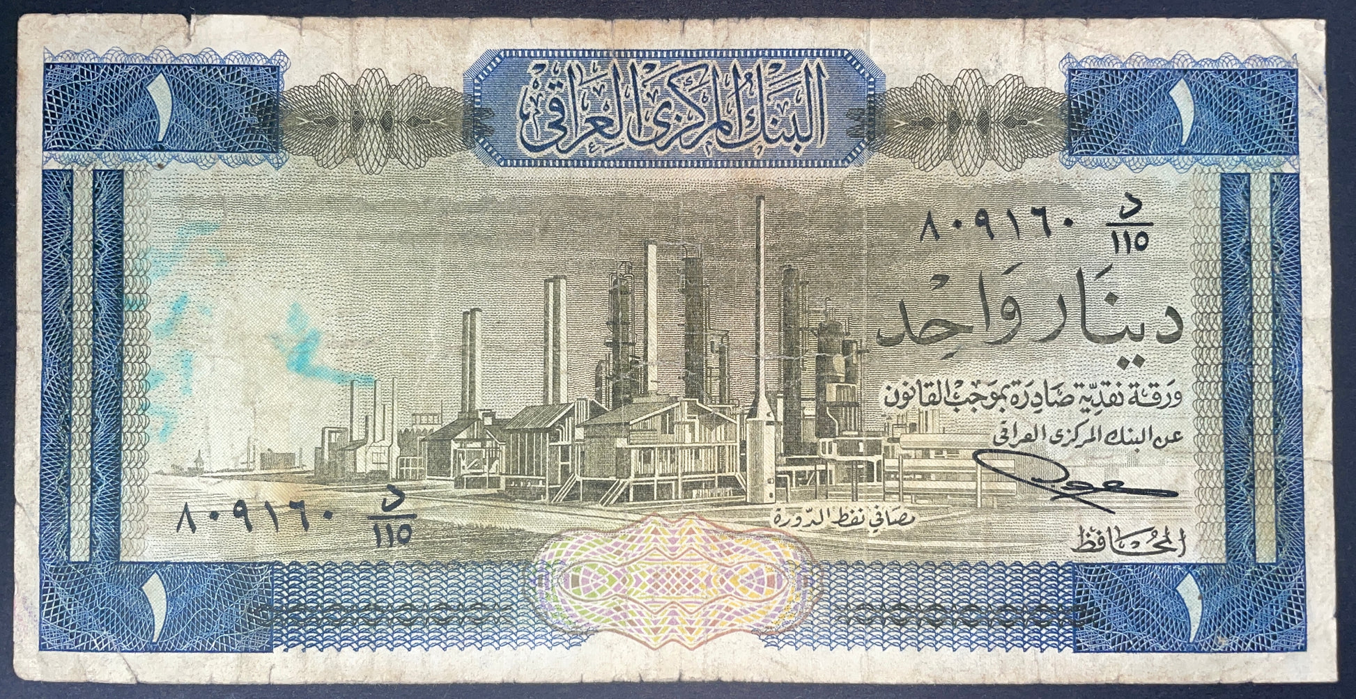 Front of Iraq 1 Dinar 1971 banknote featuring an industrial facility, Arabic text, serial number, and detailed blue security pattern