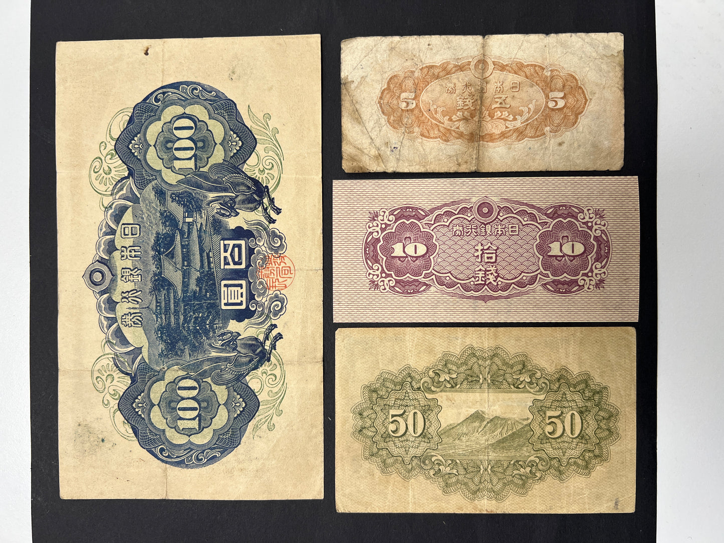 Back view of a circulated WWII Japan currency bundle showcasing intricate engravings of Mount Fuji, Horyu-ji temple, and classic guilloche patterns.
