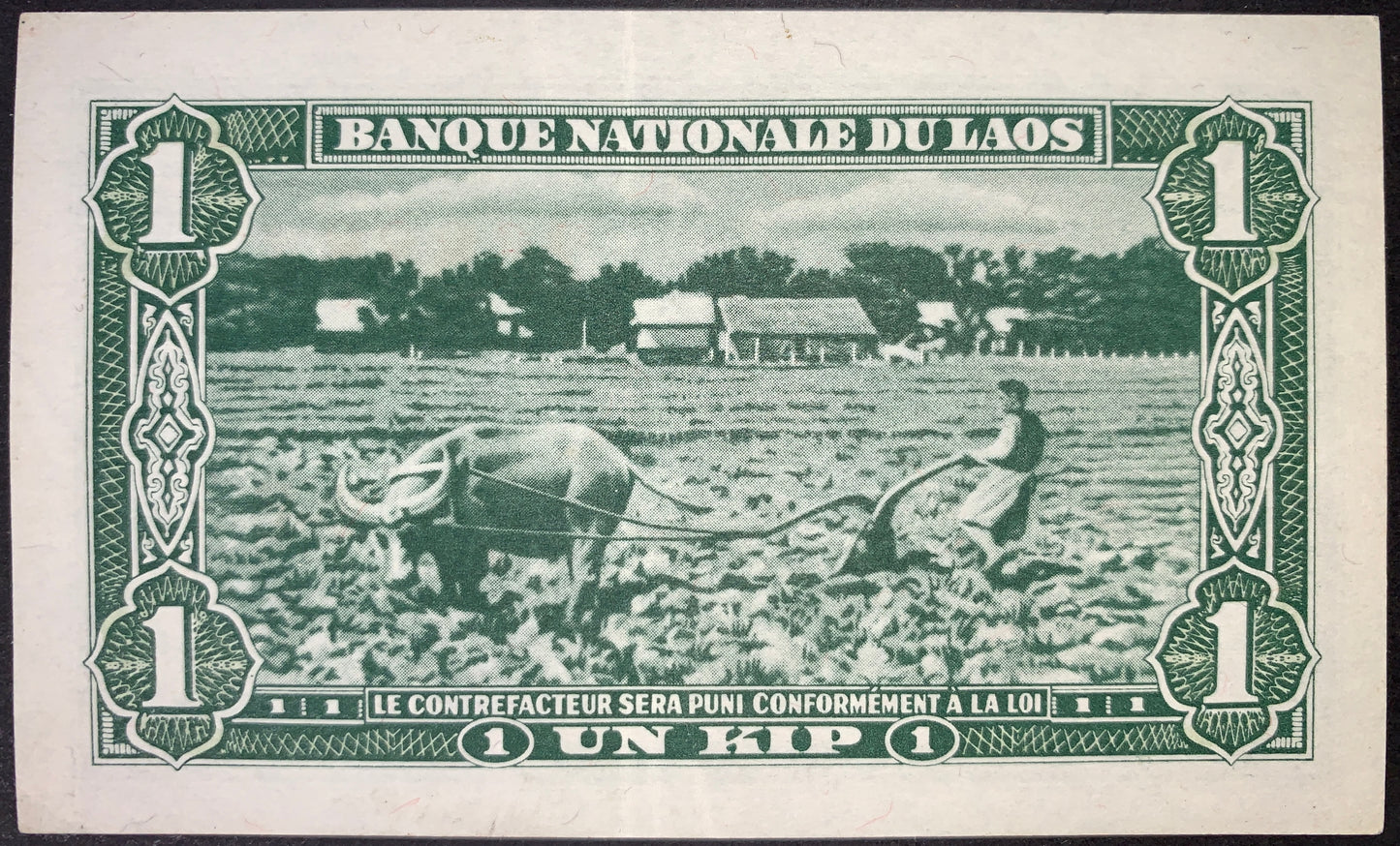 Laos 1 Kip ND (1957–1962) P-1 XF banknote reverse depicting a Lao farmer plowing a rice field with an Asian water buffalo, surrounded by French-influenced guilloche patterns and bilingual Banque Nationale du Laos and Un Kip inscriptions.