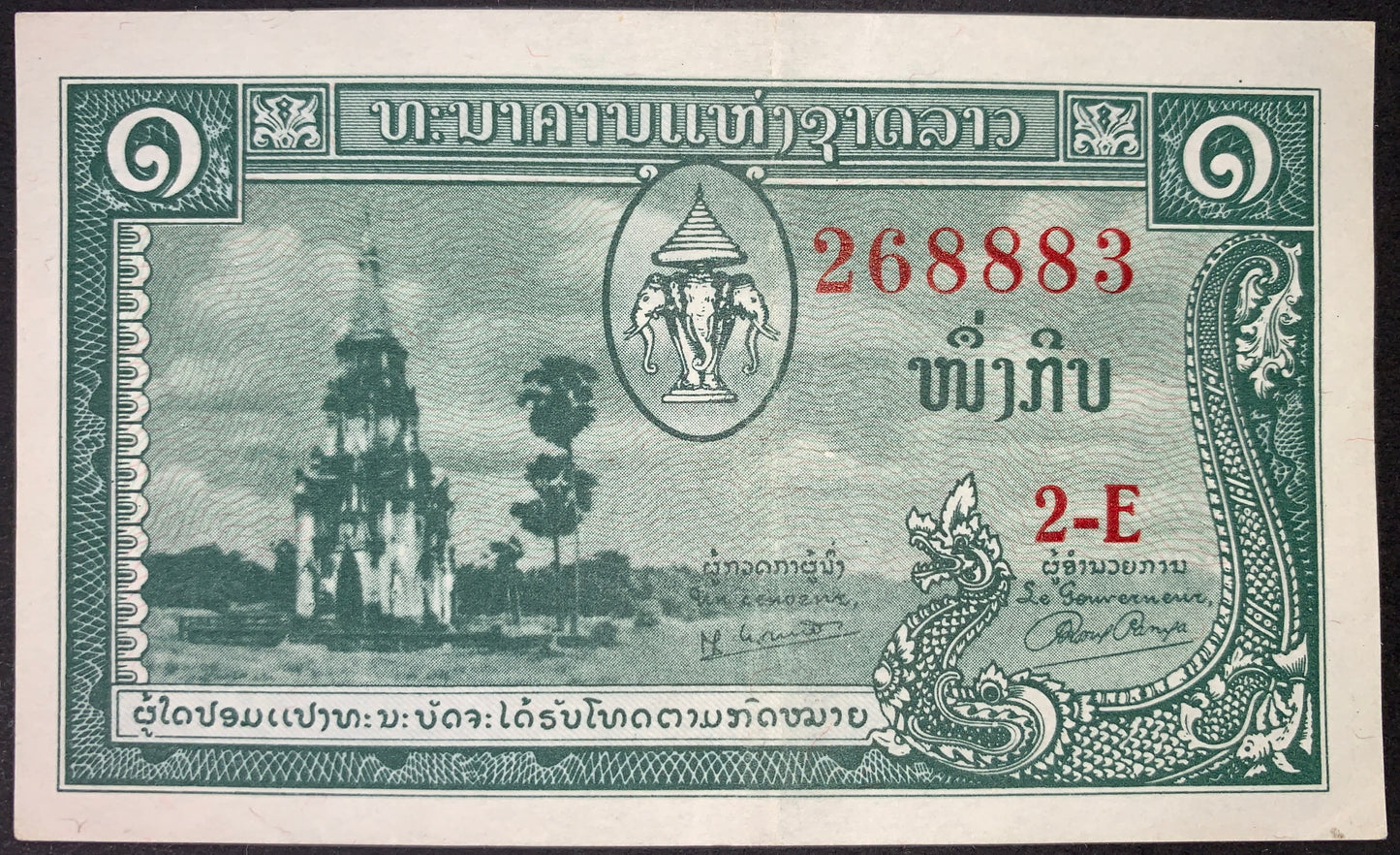 Laos 1 Kip ND (1957–1962) P-1 XF banknote obverse featuring the sacred That Ing Hang Stupa in Ban Thad, Savannakhet, the royal Erawan three-headed elephant coat of arms, native palm trees, and ornate nāga dragon designs.