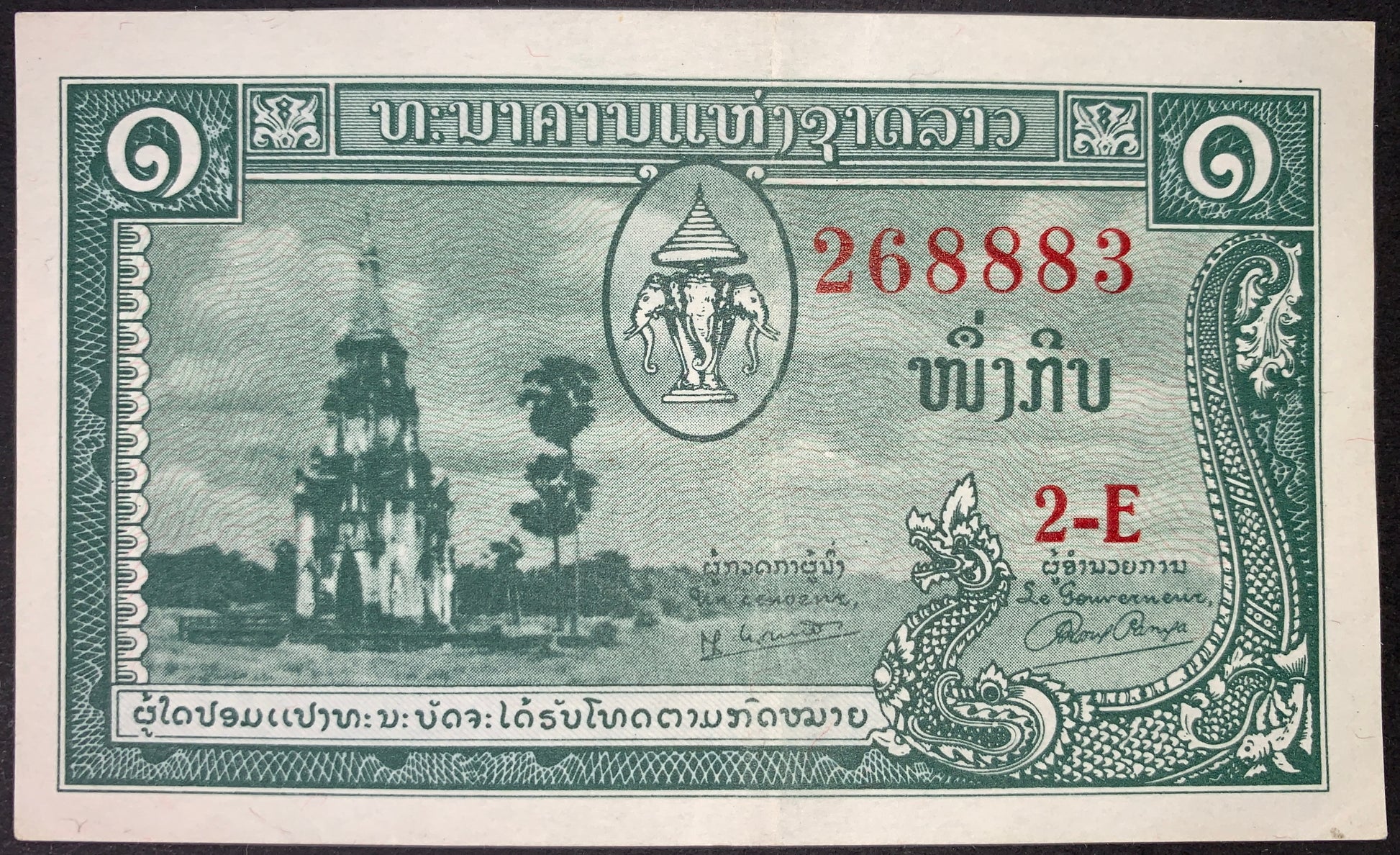 Laos 1 Kip ND (1957–1962) P-1 XF banknote obverse featuring the sacred That Ing Hang Stupa in Ban Thad, Savannakhet, the royal Erawan three-headed elephant coat of arms, native palm trees, and ornate nāga dragon designs.