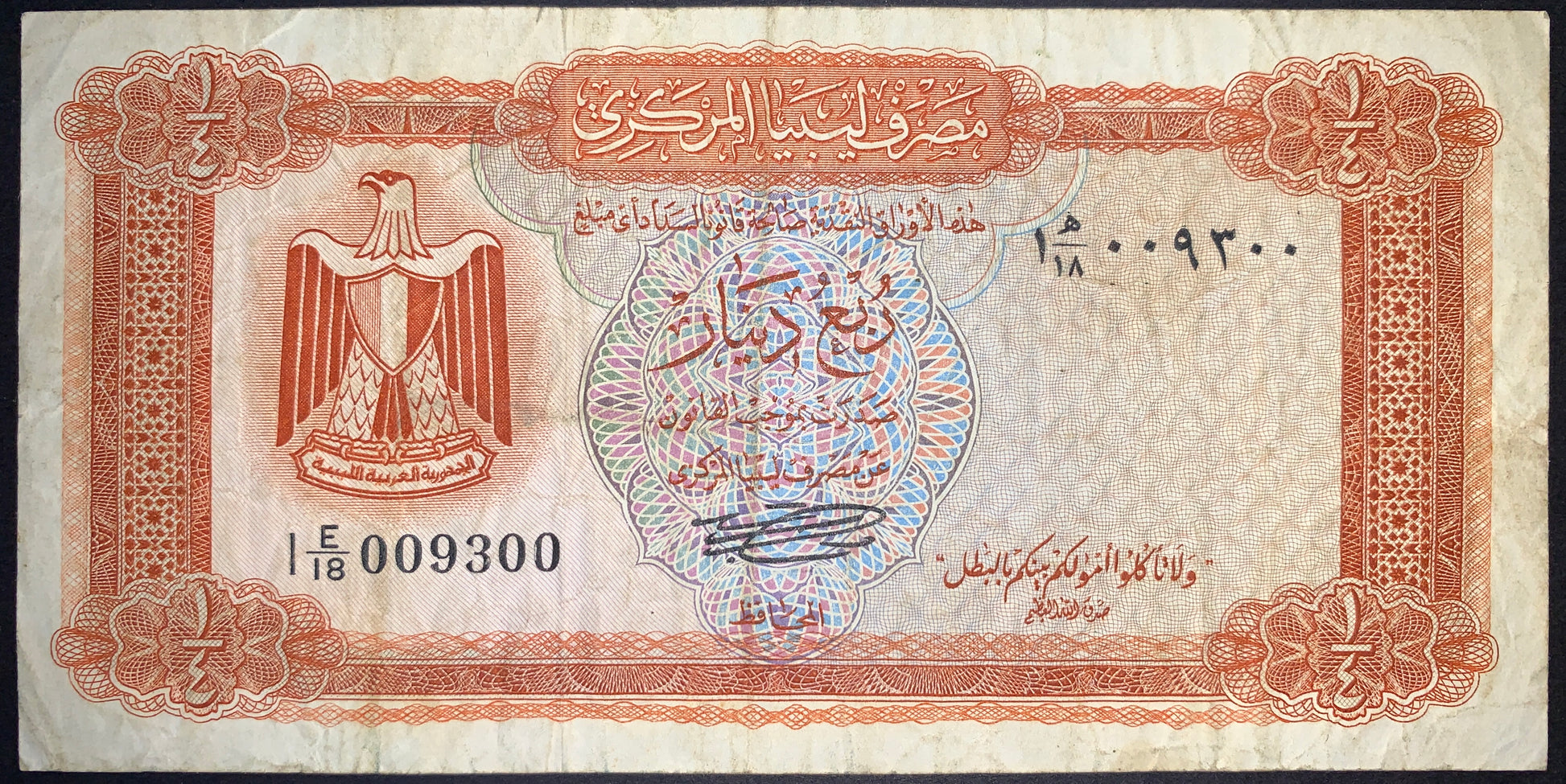 Obverse of Libya 1/4 Dinar banknote P-33b featuring the Egyptian eagle emblem, Arabic script, intricate multicolor security guilloche, brown ornamental border, and serial number. Authentic vintage Libyan banknote for world currency collectors.