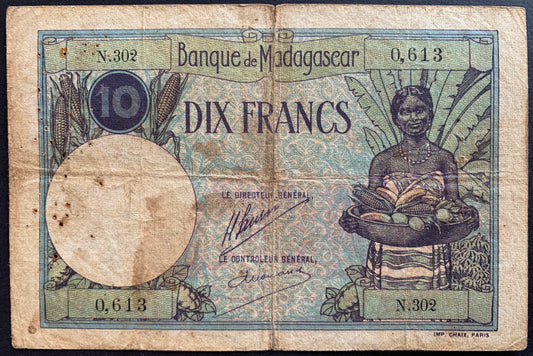 front of Madagascar 10 Francs ND (1926-1937) P-36a F+ african collectible vintage banknote with ears of corn and young woman with basket of fruits and cereals with a Ravinala (traveler's tree)