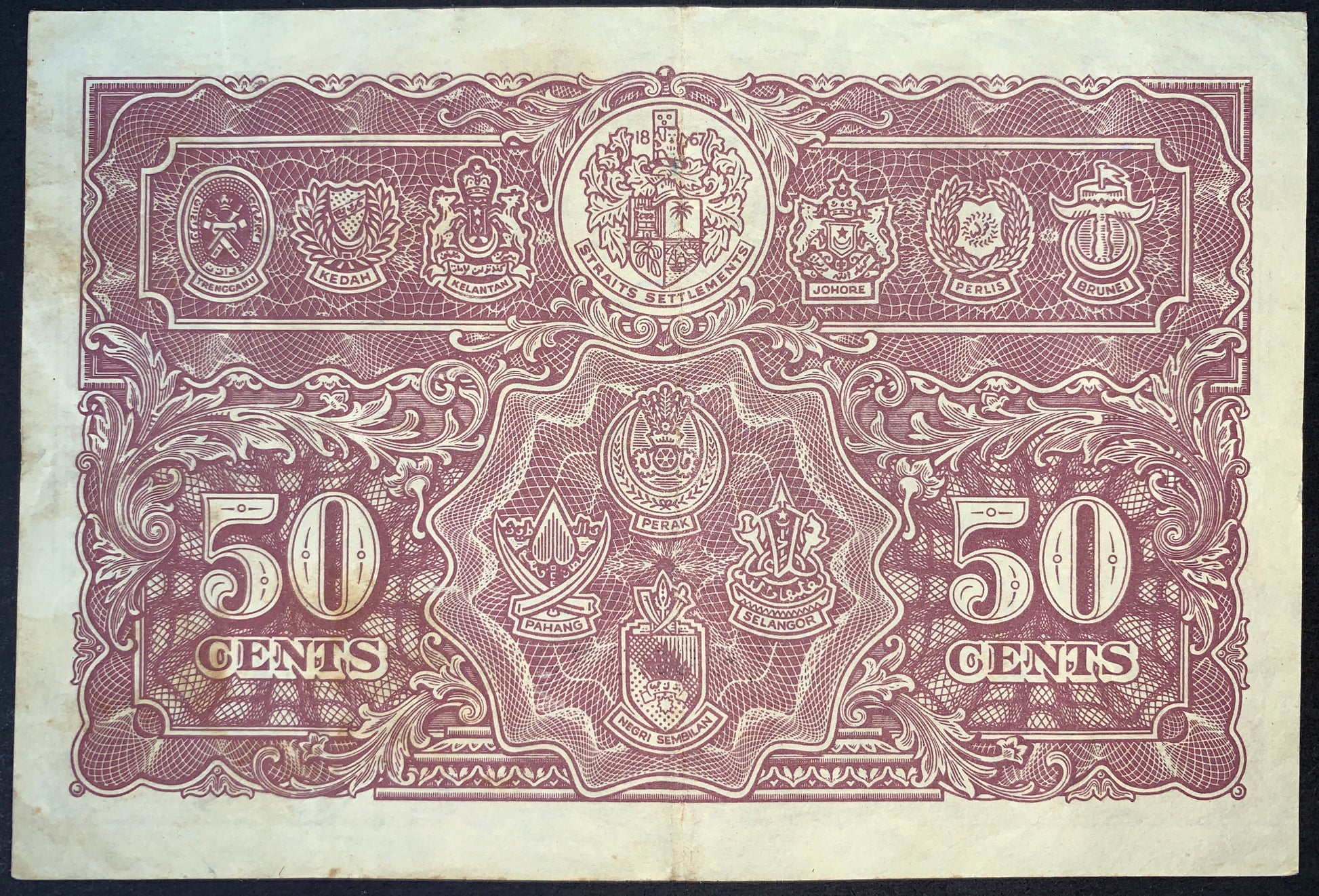 Reverse of authentic Malaya 50 Cents 1941 banknote Pick P-10 displaying the coats of arms of the Straits Settlements and Malay States, Very Fine (VF) collectible banknote.