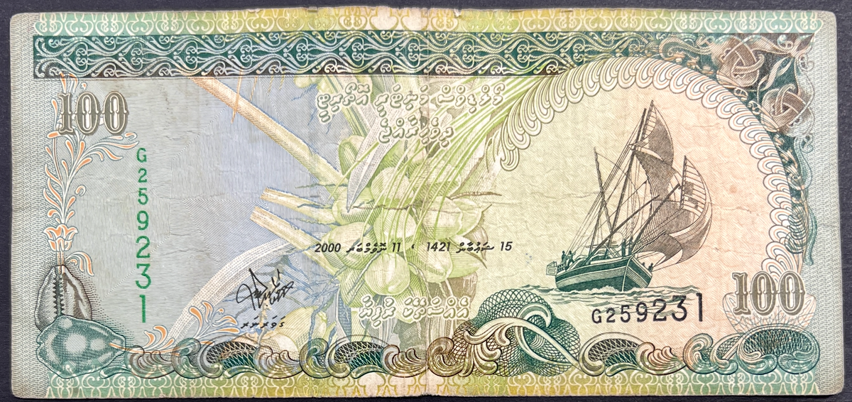 Front view of a circulated 2000 Maldives 100 Rufiyaa banknote featuring a traditional Dhoni sailing boat, a coconut palm, and a cowrie shell.
