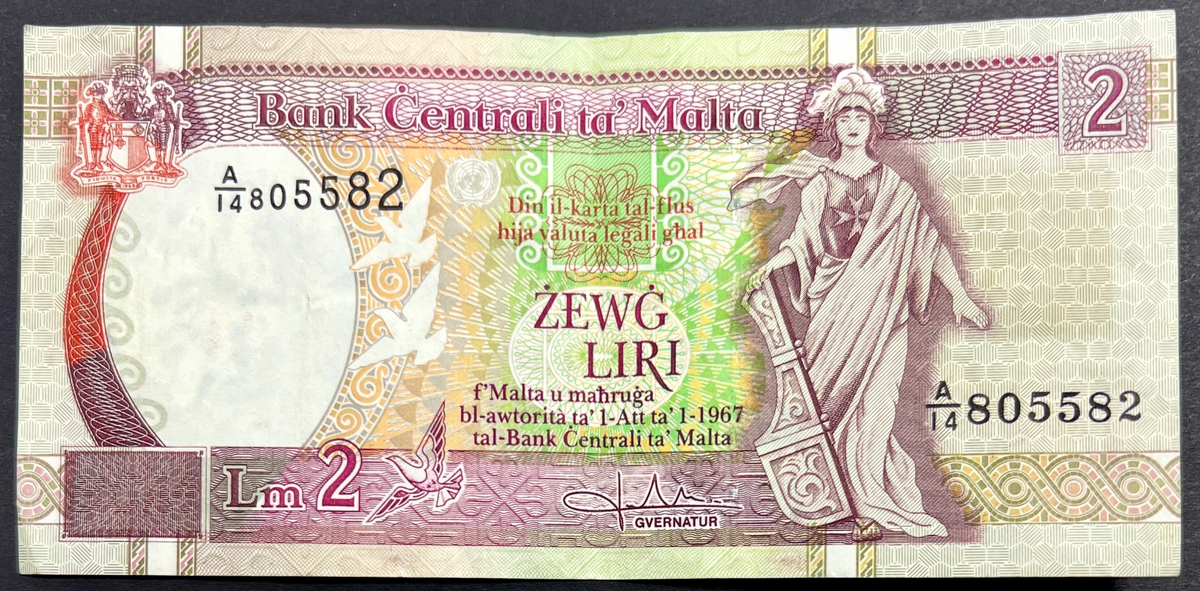 Front view of a circulated 1989 Malta 2 Liri banknote featuring the allegorical figure of Melita holding a ship's rudder and the Maltese coat of arms.