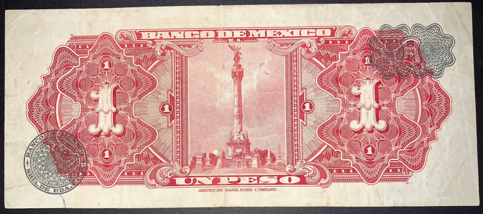 Reverse of an authentic Mexico 1 Peso banknote, 1967 issue, Pick P-59j. Features the iconic Angel of Independence monument in Mexico City surrounded by intricate red guilloche patterns, official seals, and ornate engraved details.
