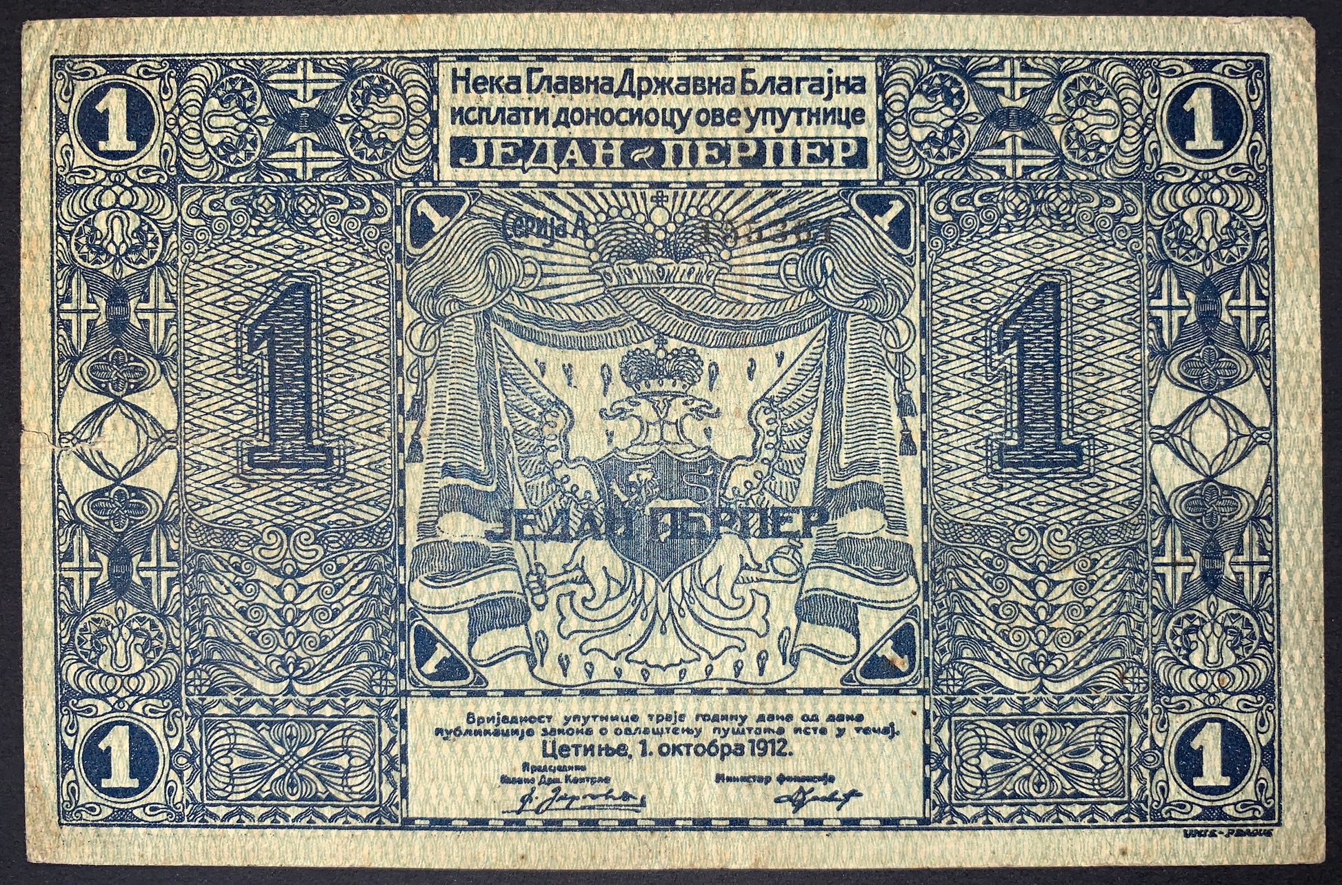 reverse of Montenegro 1 Perper 1912 P-1 banknote in Fine condition with ornate blue security engraving, denomination panels, and royal heraldic design