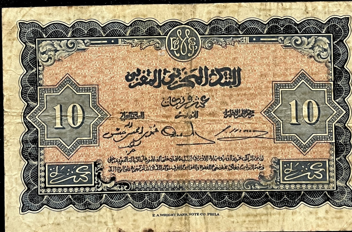 Back view of a 1943 Morocco 10 Francs banknote with Arabic script, signatures and the value in eight-pointed stars on a salmon underprint within a blue scalloped frame.