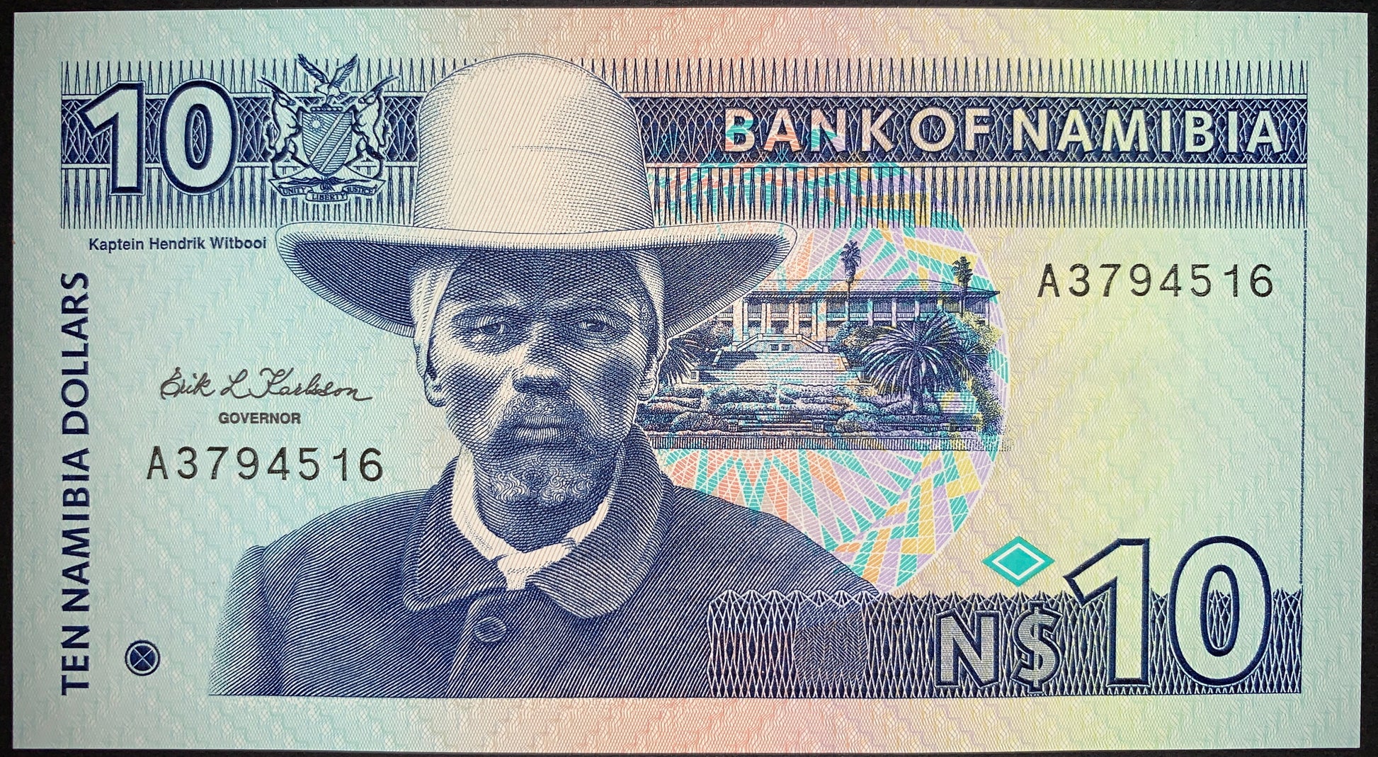 front of Namibia 10 Dollars ND (1993) P-1 UNC collectible vintage banknote with portrait of Hendrik Witbooi, Parliament building in Windhoek, Namibian Coat of Arms