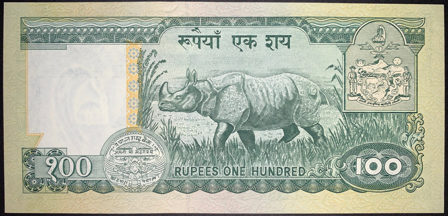 Reverse of Nepal 100 Rupees ND (1999) P-34f banknote featuring a one-horned rhinoceros in its natural habitat, the national coat of arms, denomination, and ornate security elements.