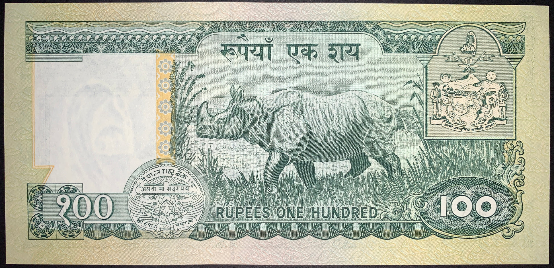 Reverse of Nepal 100 Rupees ND (1999) P-34f banknote featuring a one-horned rhinoceros in its natural habitat, the national coat of arms, denomination, and ornate security elements.