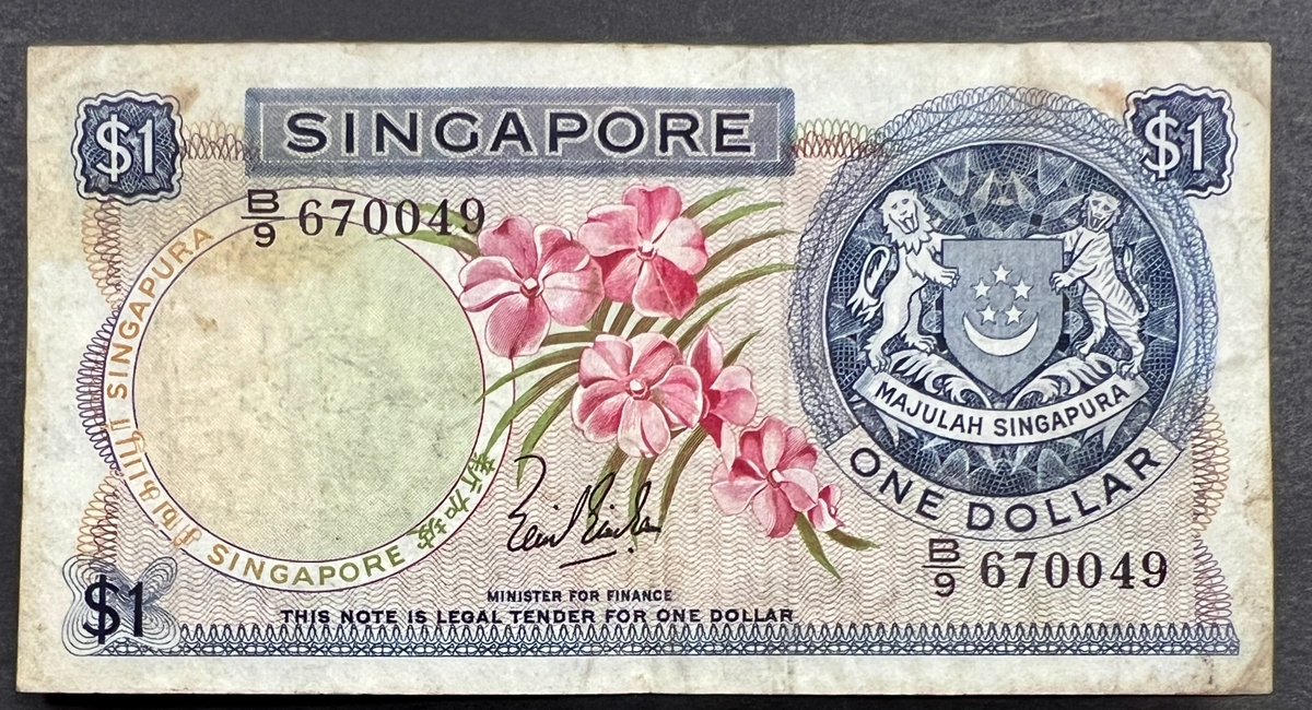 Front view of a circulated 1967 Singapore 1 Dollar banknote featuring a beautiful pink Vanda Joaquim orchid and the Singaporean national coat of arms.