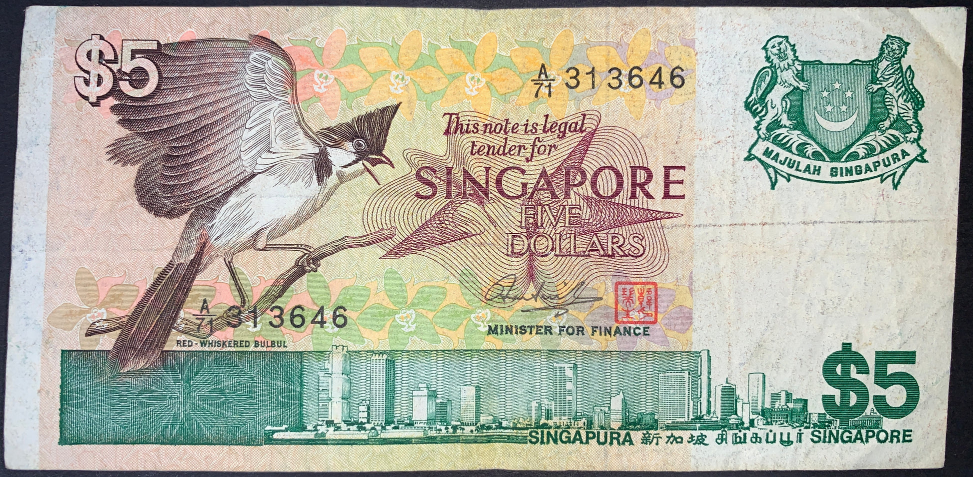 front of Singapore 5 Dollars 1976 P-10 VF collectible vintage banknote with Red-whiskered bulbul bird 