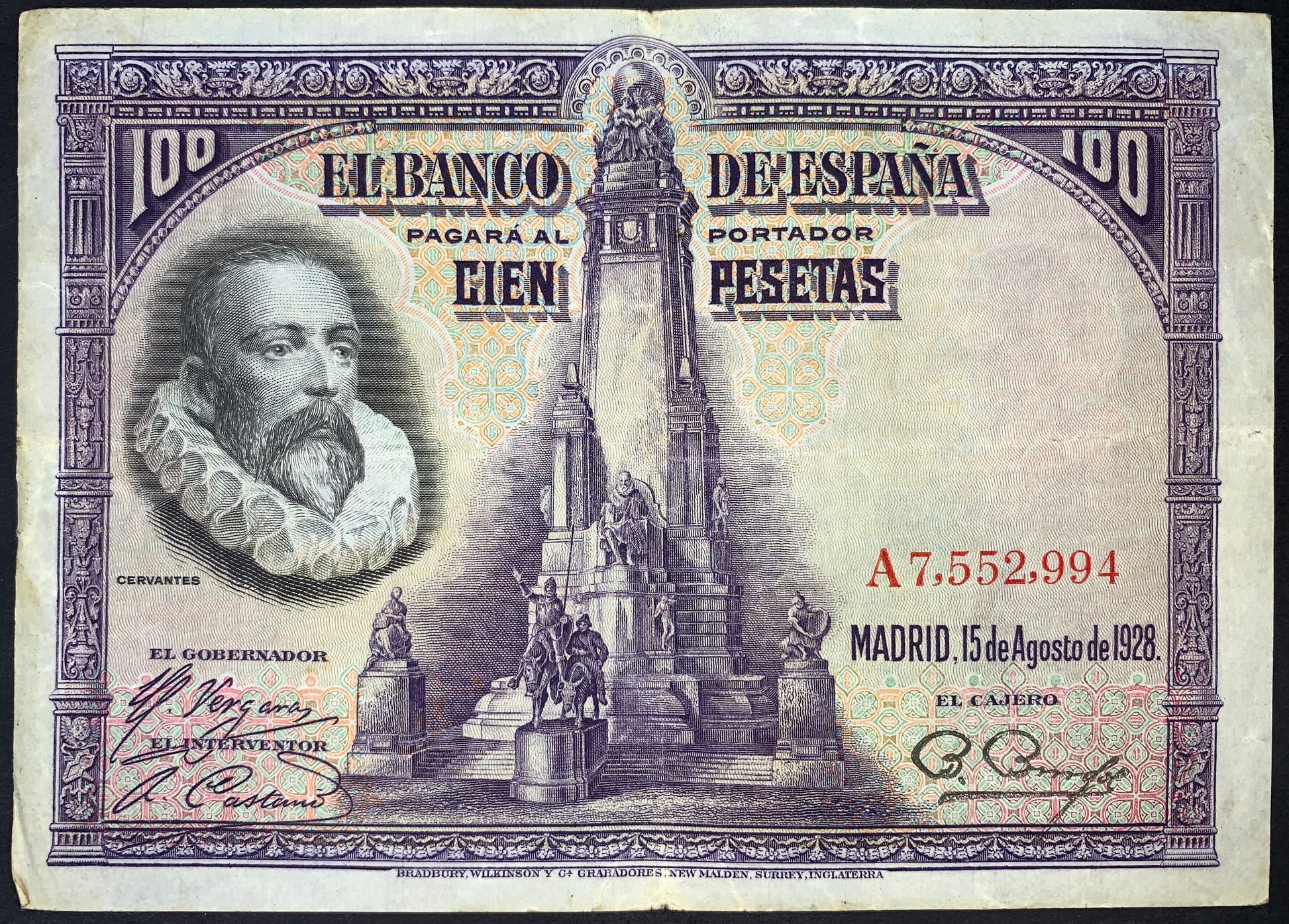 Spain 100 Pesetas banknote dated 15 August 1928 (P-76) featuring a portrait of Miguel de Cervantes alongside the Cervantes Monument in Madrid. Detailed purple engraving with ornate borders, serial numbers, and Banco de España inscriptions.