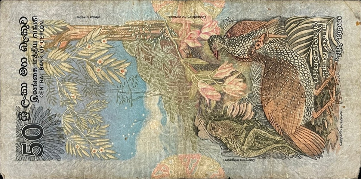 Back view of a 1979 Ceylon (Sri Lanka) 50 Rupees banknote showing a pair of Ceylon spurfowl, Vesak orchids and a kangaroo lizard.