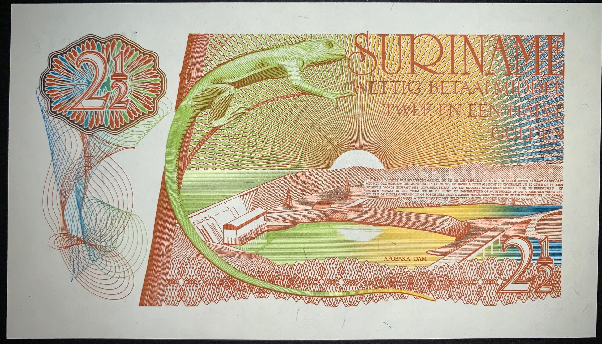 back of Suriname 2 1/2 Gulden 1985 P-119 UNC collectible vintage banknote with lizard alongside the Afobaka Dam