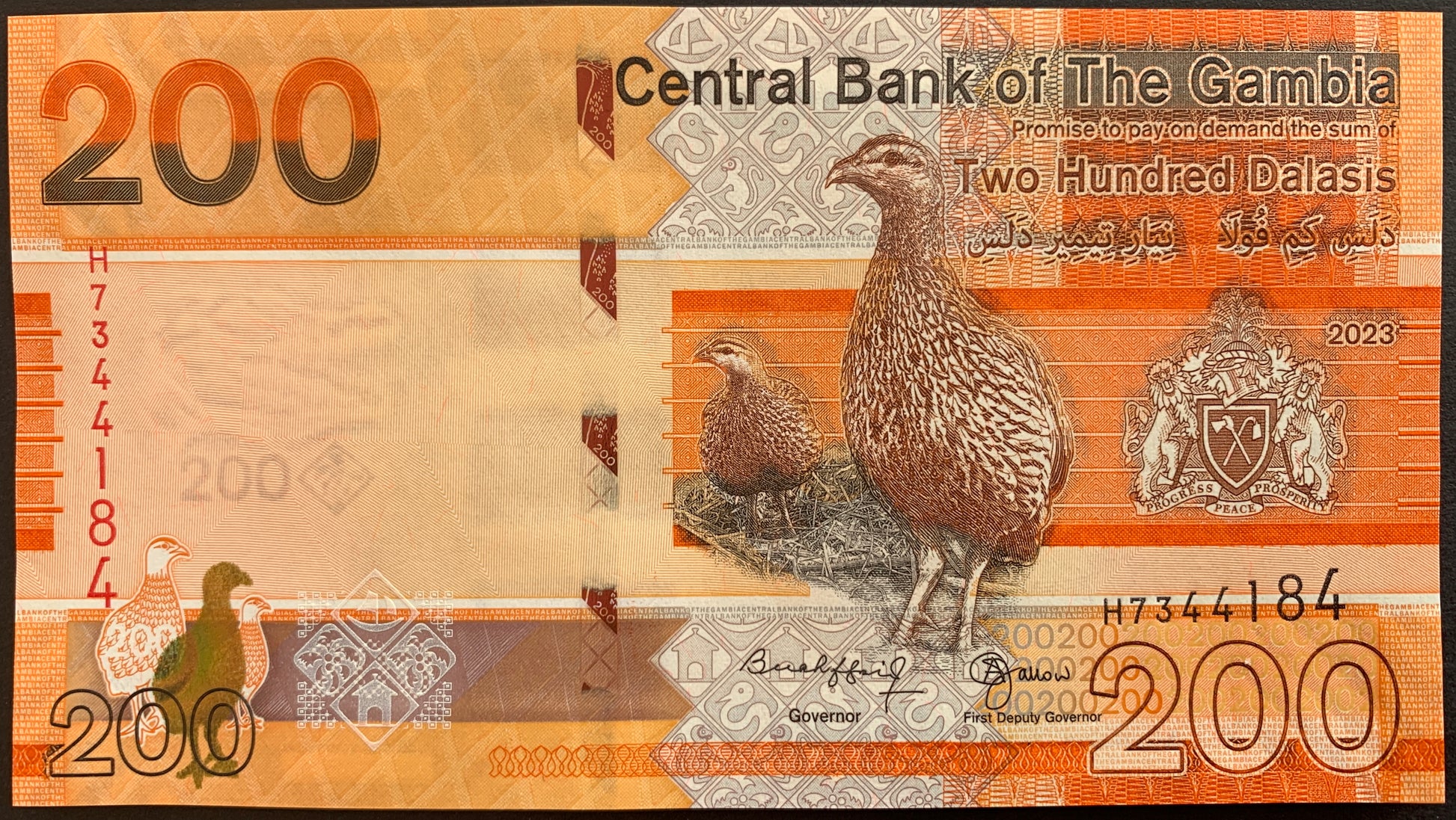 front of The Gambia 200 Dalasis 2023 collectible banknote with bush fowl bird and coat of arms