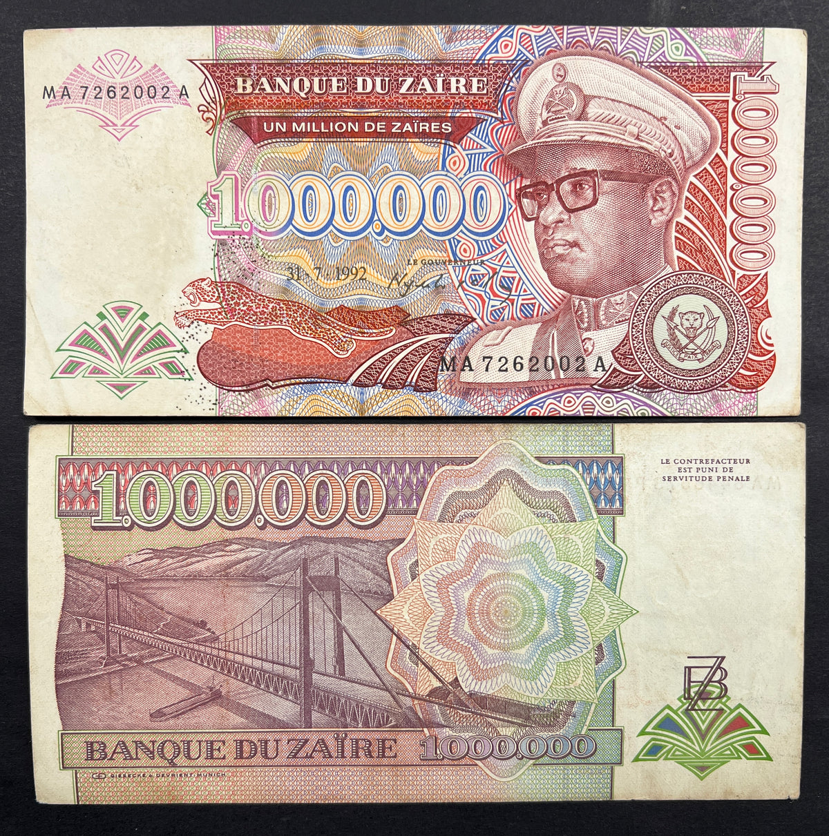 Front view of a crisp, uncirculated 1992 Zaire 1 Million Zaires banknote featuring a portrait of dictator Mobutu Sese Seko in military uniform and a leaping leopard.
Back view of a 1992 Zaire 1 Million Zaires hyperinflation banknote showcasing a detailed engraving of the Matadi Bridge spanning the Congo River.